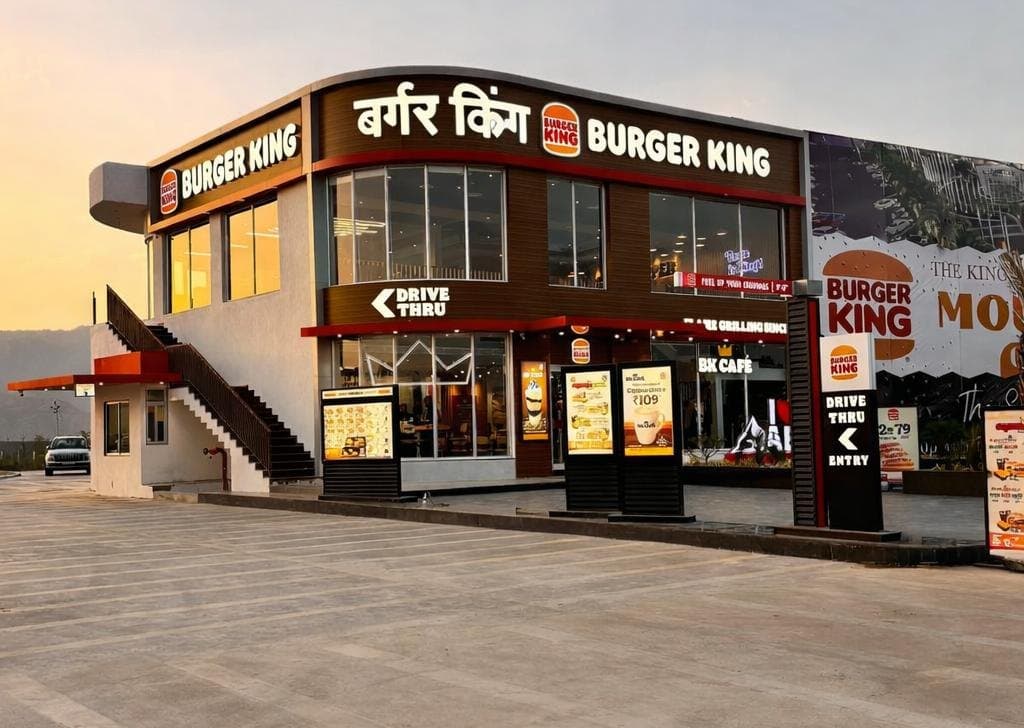 Two-storey Burger King drive-thru restaurant with a BK Café at sunset